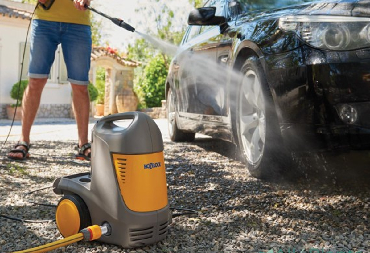 Απεικονίζεται ένας άνδρας να καθαρίζει το αυτοκίνητό του.